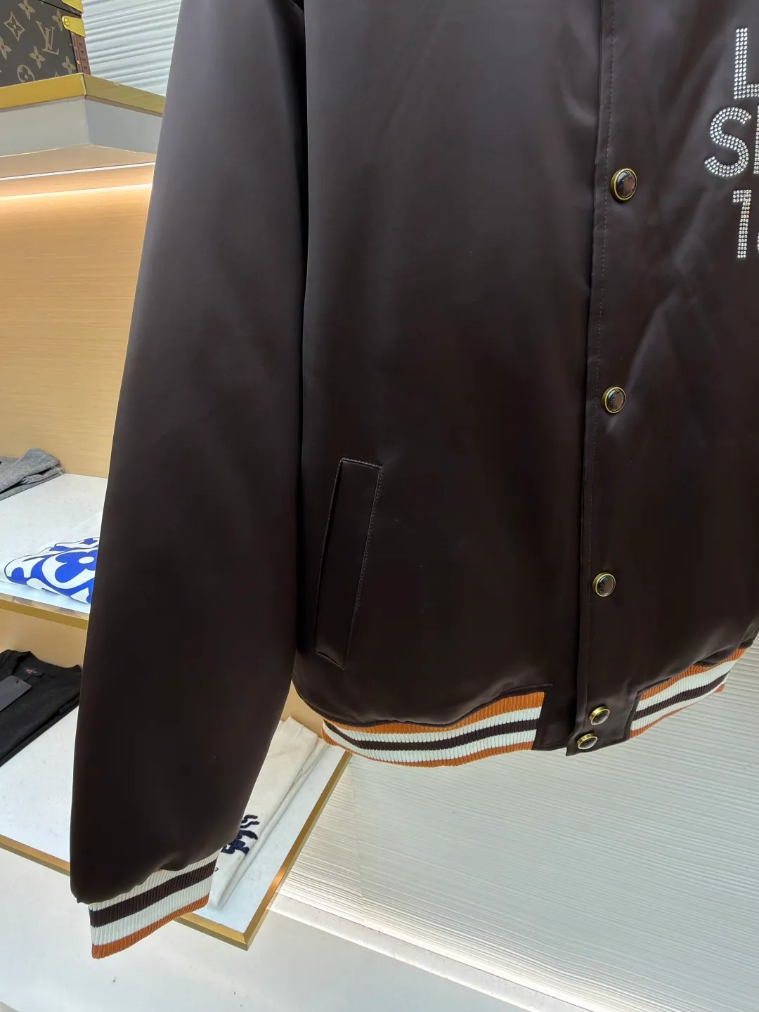 LOUIS VUITTON decorative flight jacket ●Original version: 30,000 purchased and developed ●Item number: 1682285-B90 ●Fabric: cotton fabric ●Technology: patch production ●Color: brown ●Version: fitted version ●Weight: about 1085 grams ●Size: 46-48-50-52 ●Description: The main body of this Louis Vuitton satin baseball jacket is made of high-density matte satin fabric, which has been treated with anti-wrinkle shaping technology. The fabric has a strong drape and is not easy to wrinkle. The dark brown background color is prepared by precision dyeing and finishing technology, giving it a rich color and high-end texture. The "L.V.M SINCE 1854" logo on the left chest is made with hot-drilling technology. High-quality rhinestones are used for precise hot-pasting in different areas. The diamond surface is shiny and strong and will not fall off easily. The ribbed splicing of the collar, cuffs and hem is a three-color contrasting design. It is woven with high-elastic knitted yarn, which will not easily loosen and deform after long-term wear. The placket is equipped with custom-made metal snaps. The hardware is thick and anti-oxidation. The overall style is loose and off-shoulder. The splicing is covered with blind stitching technology, and the wiring is smooth and traceless. Every craft detail follows the brand's luxury product production standards, taking into account both design and wearing comfort. The overall wiring is straight and delicate, the fabric is comfortable and soft, and the color is consistent without color difference. It can be matched with the same style to create a fashionable look and control various occasions. Customized accessories, complete with three standards, same style for men and women!
